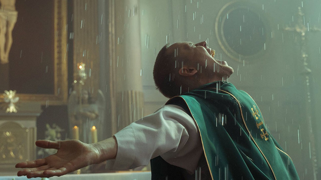Pater Tomasz unterm Weihwasser-Regen (Bild: Aurum Film)